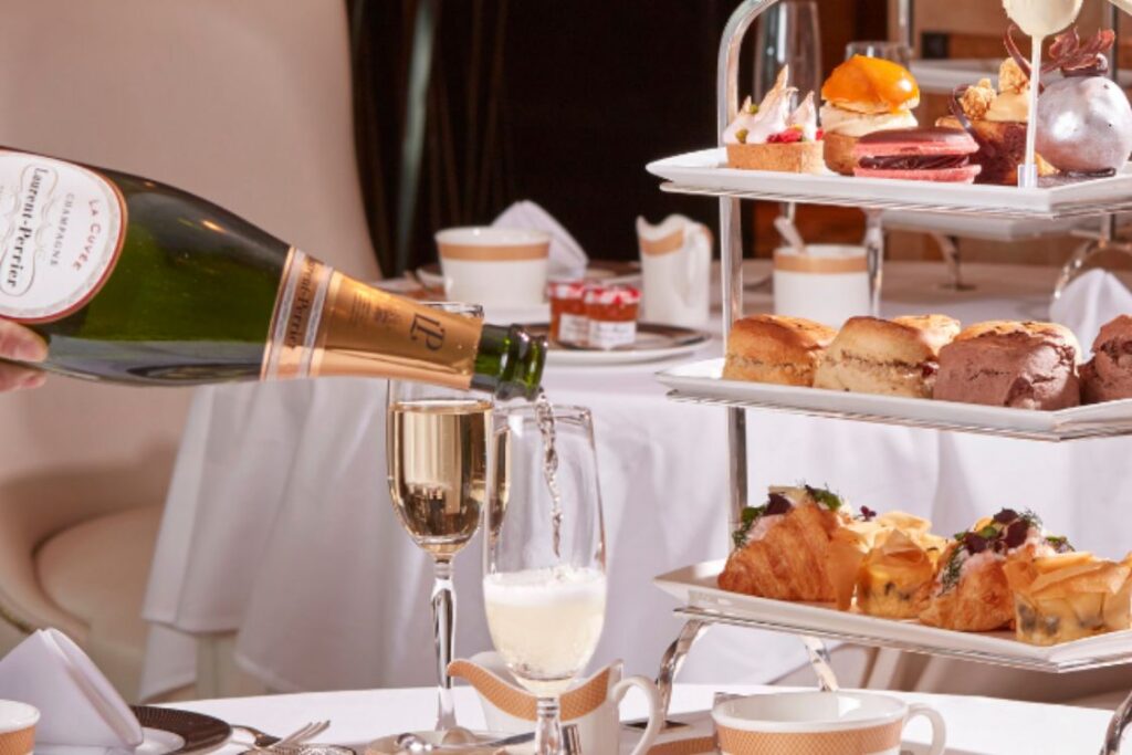 Bottle of champagne being poured at afternoon tea